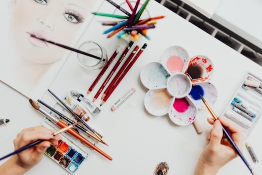 pexels photo 4012974 4012974 Flat lay of art supplies, including brushes and paint, used in creating a colorful portrait.